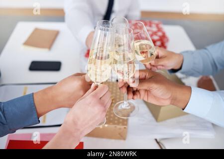 Gros plan sur un groupe de gens d'affaires inconnus assis ensemble et toaster avec des verres à champagne pour Noël au bureau. Une équipe de collègues fêtant Banque D'Images