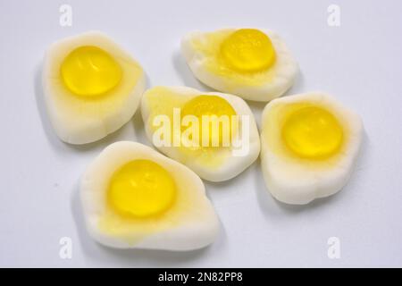 La mastication lumineuse pour enfants, les bonbons en gelée sous forme de nourriture et les œufs brouillés frits sont situés sur un fond blanc. Banque D'Images