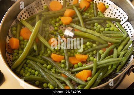 assortiment de divers types de légumes cuits dans un cuiseur vapeur métallique Banque D'Images