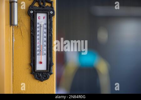 Vue du thermomètre extérieur sur pilier en bois jaune en hiver. Suède. Banque D'Images