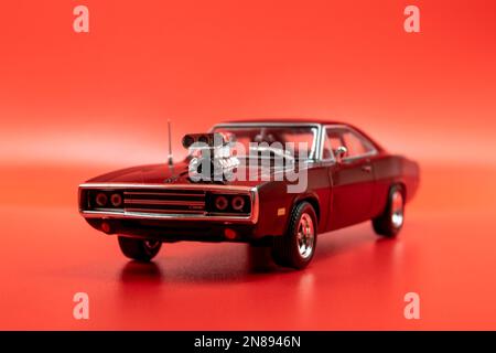 Fast&Furious Dodge Charger R/T (1970) modèle 1:43, vue avant, arrière-plan rouge Banque D'Images