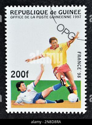 Timbre-poste annulé imprimé par la Guinée, qui montre les joueurs de football, faisant la promotion de la coupe du monde de la FIFA en France 98, vers 1997. Banque D'Images