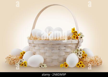 Panier de Pâques rempli d'œufs avec décorations de printemps de fleur et nids de paille, isolé sur fond beige, modèle pour étiquette, carte de voeux cadeau, adver Banque D'Images