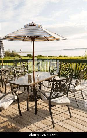 Meubles de patio sur la terrasse avec vue sur le lac à Summertime, Nouvelle-Écosse Banque D'Images