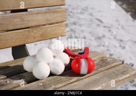 Boules de neige et outil en plastique sur le banc à l'extérieur Banque D'Images