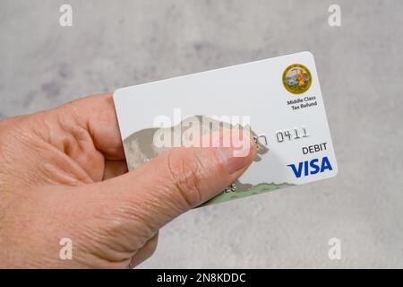 Lac Elsinore, CA - 14 décembre, 2022: Man's had Holding Californie carte de débit de remboursement de taxe de classe moyenne. Banque D'Images