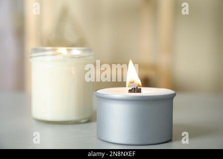 Bougies allumées dans les supports de la table gris clair Banque D'Images