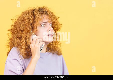 Une femme effrayée parle au téléphone portable Banque D'Images