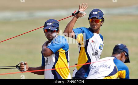 Sri Lankan cricketers Jeevan Mendis, left, and Dinesh Chandimal perform stretching exercises during a training session ahead of their ICC Twenty20 Cricket World Cup match against New Zealand in Kandy, Sri Lanka, Tuesday, Sept. 25, 2012. (AP Photo/Aijaz Rahi)