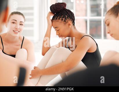 Nous partageons les uns les autres, plus près que plus loin. un groupe de danseurs de ballet assis ensemble en regardant stressé. Banque D'Images