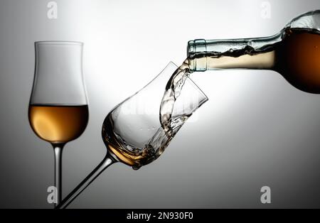 Verres d'alcool de première qualité. La boisson est versée d'une bouteille dans un verre. Copier l'espace. Banque D'Images