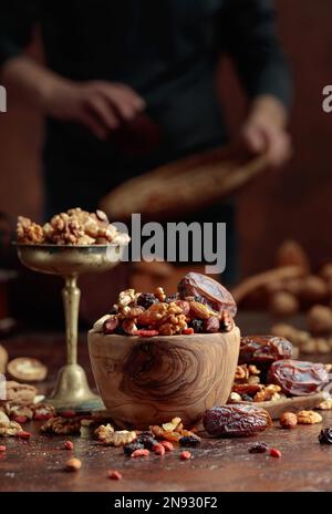 Divers fruits secs et noix sont dans un bol en bois sur une table de cuisine. Mise au point sélective. Banque D'Images