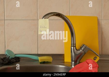 Apprendre l'anglais en utilisant des cartes accrochées dans la cuisine et sur le robinet à l'évier dans l'appartement, apprendre une langue étrangère Banque D'Images