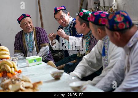 (230212) -- URUMQI, le 12 février 2023 (Xinhua) -- Sulayman Abdu (1st L), un artiste muqam, discute avec d'autres artistes folkloriques à sa résidence dans le village de Muqam, dans la ville de Lukqun, dans le comté de Shanshan, dans la région autonome de Xinjiang Uygur, dans le nord-ouest de la Chine, le 11 janvier 2023. Le Muqam est l'art traditionnel du groupe ethnique uygur au Xinjiang. (Xinhua/Zhao GE) Banque D'Images