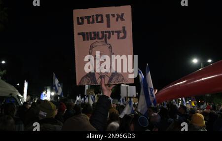JÉRUSALEM, ISRAËL - FÉVRIER 11 : Un manifestant tient un panneau avec la figure du Premier ministre Benjamin Netanyahu qui dit « il n'y a pas de mandat pour un dictateur » lors d'une manifestation contre le nouveau système judiciaire gouvernemental d'Israël qui vise à affaiblir la Cour suprême du pays en dehors de la résidence du Président sur 11 février 2023, À Jérusalem, Israël. Des dizaines de milliers de personnes se rassemblent pour la sixième semaine consécutive à travers Israël contre la réforme vaste et controversée du système juridique israélien. Crédit : Eddie Gerald/Alay Live News Banque D'Images
