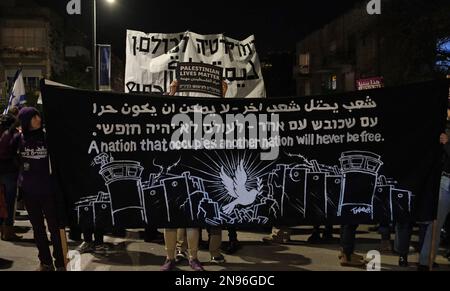 JÉRUSALEM, ISRAËL - FÉVRIER 11 : Les manifestants brandissent une bannière qui se lit comme « Une nation qui occupe une autre nation ne sera jamais libre » comme des slogans scandeux lors d'une manifestation contre le nouveau système judiciaire gouvernemental d'Israël qui vise à affaiblir la Cour suprême du pays en dehors de la résidence du Président sur 11 février 2023, à Jérusalem, en Israël. Des dizaines de milliers de personnes se rassemblent pour la sixième semaine consécutive à travers Israël contre la réforme vaste et controversée du système juridique israélien. Crédit : Eddie Gerald/Alay Live News Banque D'Images