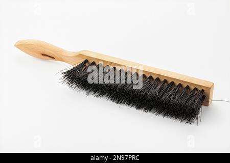 Brosse pour nettoyer la surface avec une poignée en bois sur fond blanc. Outil de construction. Banque D'Images