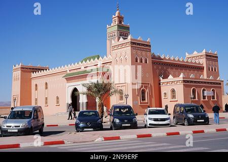 Voitures devant la mosquée dans la ville africaine de Zagora dans la région de Draa Tafilalet au Maroc, ciel bleu clair en 2023 chaude et ensoleillée jour d'hiver le janvier. Banque D'Images