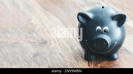 banc de porc noir sur table en bois avec espace de copie sur le côté gauche Banque D'Images