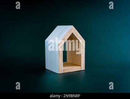 Maison, maison, famille, immobilier, concepts de propriété. Petite maison en bois miniature blanc minimal isolée sur fond vert foncé. Banque D'Images