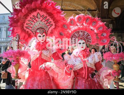 Venise, Italie. 12th févr. 2023. Un couple allemand avec des tenues roses élaborées. Les participants et les fêtards costumés se mêlent aux touristes, aux visiteurs et aux habitants de la région tandis que le carnaval bat son plein dans les rues et les places de Venise. Credit: Imagetraceur/Alamy Live News Banque D'Images