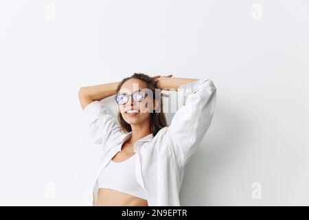 Portrait de femme avec peau bronzée portant des lunettes de vue sur un fond blanc souriant avec les dents et les mains en haut dans la joie Banque D'Images