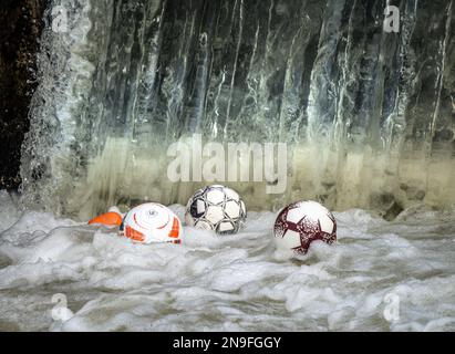 12 février 2023, Hesse, Francfort-sur-le-main: Des ballons de football dansent sur l'eau à un déversoir sur le fleuve Nidda, où ils sont pris dans le sous-sol de l'eau. La petite rivière passe devant de nombreux terrains de sport et installations de loisirs dans le nord de Francfort et les villes voisines, d'où les balles continuent de tomber dans l'eau. Photo: Frank Rumpenhorst/dpa/Frank Rumpenhorst/dpa Banque D'Images