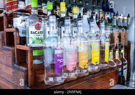 Photo de plusieurs bouteilles de rhum colorées dans un bar sur un bateau touristique. Banque D'Images