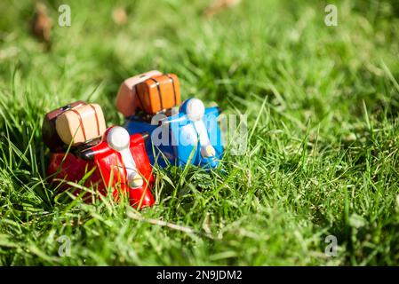 Le concept de voyager sur des cyclomoteurs au printemps ou en été. Figurines de mobylette sur l'herbe verte au soleil. Banque D'Images