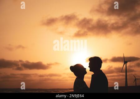 Couple libre appréciant la Saint Valentin dans la lumière dorée. Banque D'Images