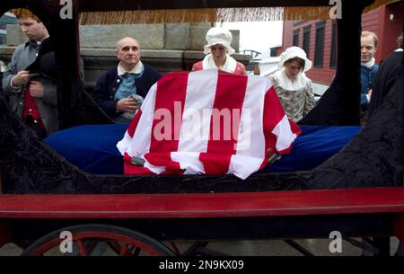 Colonial reenactors watch as a carriage carrying one of the original tea chests from the 1773 Boston Tea Party, draped in the American flag, processes to the Boston Tea Party Ships and Museum, in Boston, Wednesday, June 13, 2012. The Robinson Half Tea Chest, which was recovered from sand off Boston Harbor the morning after colonists tossed 340 tea chests into the water in an act of rebellion, is believed to be one of two remaining. The chest, will make its way from the Old South Meeting House to the Boston Tea Party Ships and Museum, which is slated to open June 26. (AP Photo/Steven Senne)
