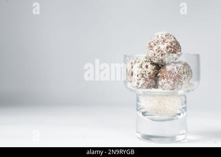 Truffes au chocolat et à la noix de coco, bonbons au chocolat faits maison sur fond blanc, truffes séchées enrobées de noix de coco Banque D'Images