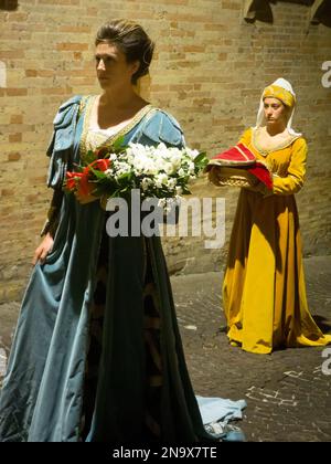 Lady et sa femme de ménage vêtues de costume médiéval fin, Renaissance tôt en train de défiler les rues de la ville la nuit, Fermo, Marche, Italie © Renzo Frontoni / Axio Banque D'Images