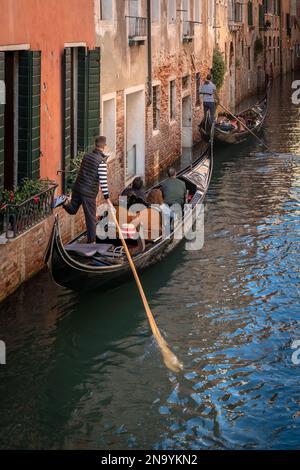 Le gondolier pousse la gondole hors du mur sur un canal de Venise Banque D'Images