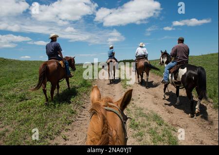 Les éleveurs à cheval suivent un chemin de terre ; Burwell, Nebraska, États-Unis d'Amérique Banque D'Images