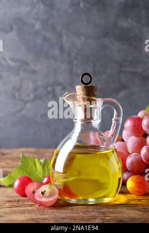 Verseuse d'huile de pépins de raisin naturel sur table en bois. Cosmétique biologique Banque D'Images