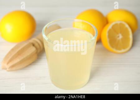 Jus fraîchement pressé, citrons et alésoir sur une table en bois blanc Banque D'Images