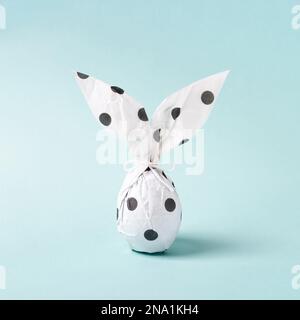 Lapin de Pâques en papier d'emballage. Concept de cadeau DIY. Œuf de Pâques comme lapin blanc. Carte de vœux de Pâques, style minimaliste. Banque D'Images