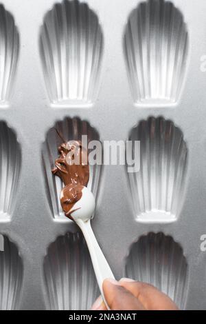 Chocolat fondu dans une casserole de madeleine, processus de fabrication de madeleines enrobées de chocolat Banque D'Images