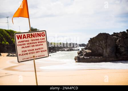 Un panneau d'avertissement à la plage sur la rive nord d'Oahu, Hawaï Banque D'Images