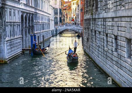 Gondole et gondolier avec des touristes dans un canal ; Venise, Italie Banque D'Images