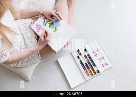 Une femme dessine dans une vue de dessus aquarelle Banque D'Images