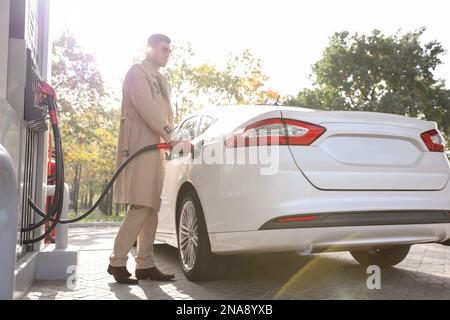 Homme ravitailleur en voiture à la station-service libre-service Banque D'Images