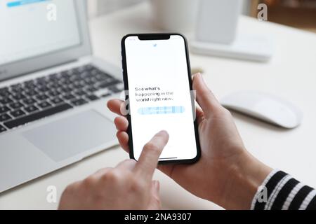 MYKOLAIV, UKRAINE - 28 AOÛT 2020: Femme tenant l'iPhone 11 avec l'application Twitter à l'écran à la table, gros plan Banque D'Images