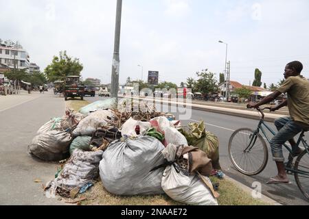 Dar es Salaam, Tanzanie. 8th févr. 2023. Un cycliste passe les déchets recueillis sur le bord de la route à Dar es-Salaam, Tanzanie, le 8 février 2023. POUR ALLER AVEC "la campagne de collecte des déchets de la Tanzanie cherche à promouvoir le tourisme durable" Credit: Herman Emmanuel/Xinhua/Alamy Live News Banque D'Images