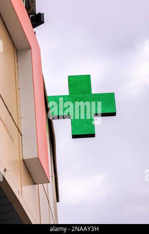 Affiche verte croisée de pharmacie sur un bâtiment rapproché Banque D'Images