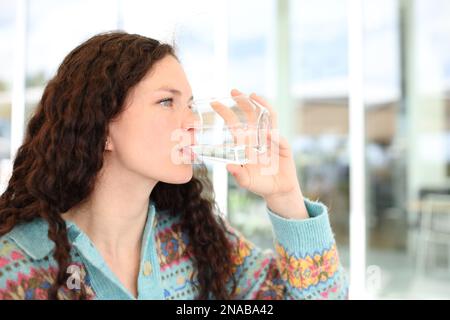 Femme buvant de l'eau du verre dans une terrasse de restaurant Banque D'Images