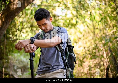 Un homme asiatique fatigué et épuisé avec un équipement de randonnée dans la montagne rocheuse. concept d'activités de plein air d'aventure Banque D'Images