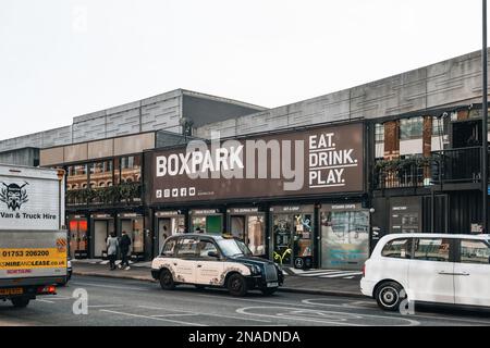 Londres, Royaume-Uni - 09 février 2023: Taxi en face des magasins à Boxpark Shoreditch, Londres, expédition container pop-up Mall pour indépendant et la mode et l Banque D'Images