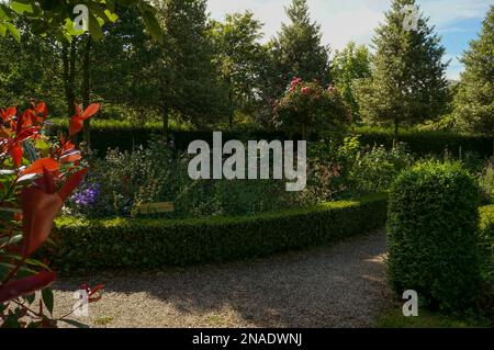 Parterres fleuris bordées de haies au jardin d'elle Banque D'Images